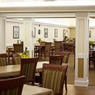 An empty dining room with neatly arranged tables and chairs.