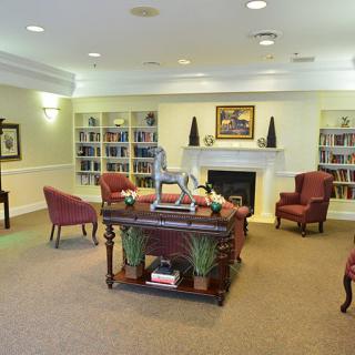 A cozy living room featuring bookshelves, a fireplace, and comfortable seating.