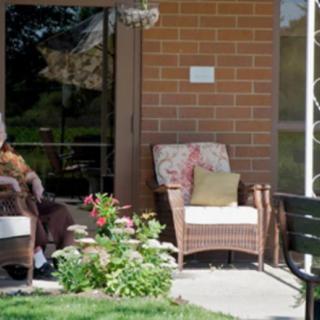 A cozy patio with wicker chairs and vibrant plants, perfect for relaxation.