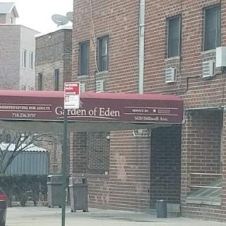 Entrance of a residential building featuring a brick facade and an awning.