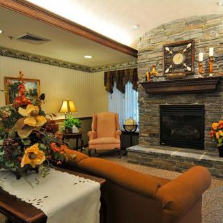 A cozy living room with a stone fireplace and elegant furniture.