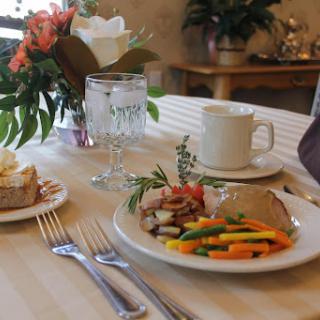 A beautifully set table featuring a delicious meal with colorful vegetables and fresh flowers.