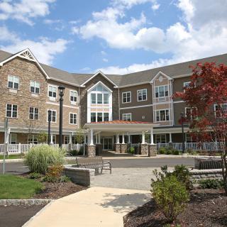 A residential building with neatly landscaped grounds and a clear blue sky.