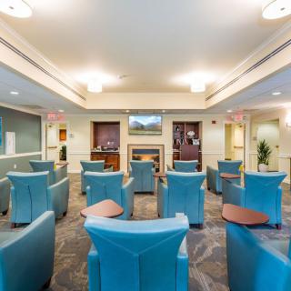 A modern waiting room with comfortable seating and a television.