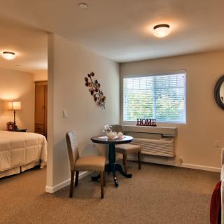 A cozy apartment interior with a small dining area and view into the bedroom.