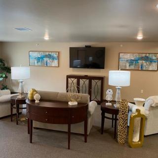 A cozy living room with comfortable seating, lamps, a coffee table, and decorative artwork.