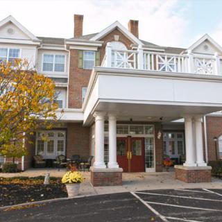 Front entrance of a multi-story building with columns and large windows.