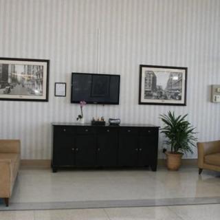 A modern living room with sofas, a television, and framed artwork on the walls.