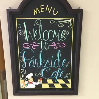 A charming welcome sign for Parkside Cafe, featuring colorful chalkboard art.