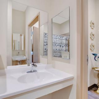 A clean and modern bathroom featuring a sink with a sleek faucet and two mirrors.