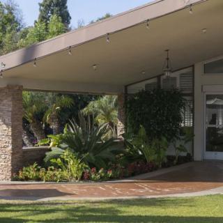A modern house with a landscaped front yard under clear skies.