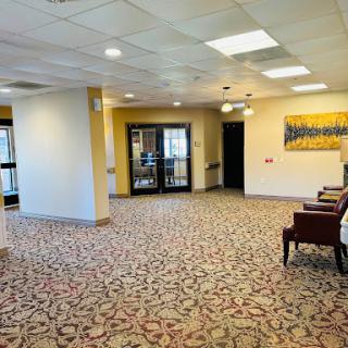 A spacious and inviting lobby area featuring comfortable seating and decorative carpeting.