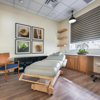 A serene therapy room with a massage table and calming decor.