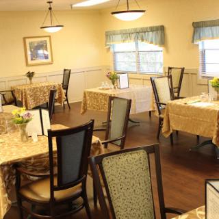 A cozy dining area featuring neatly arranged tables and chairs under soft lighting.