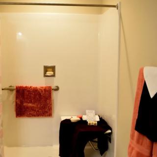 A cozy bathroom with a shower and neatly arranged towels.