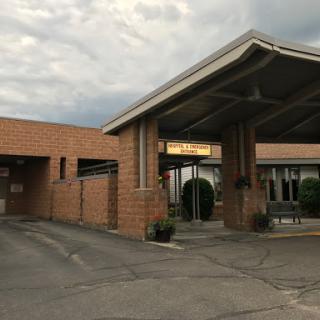 The welcoming entrance of a hospitality establishment under a cloudy sky.