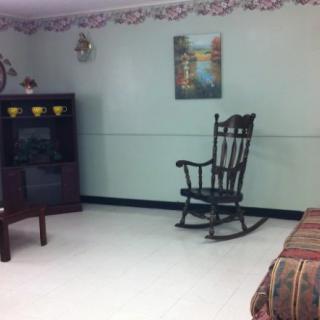 A cozy living room with a rocking chair, TV stand, and decorative elements.