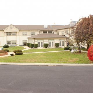 A residential building with well-maintained landscaping and a spacious lawn.