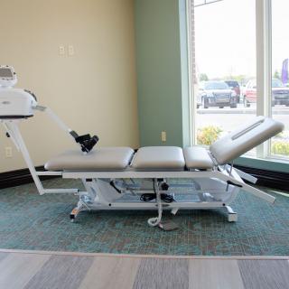 A chiropractic table in a healthcare setting, used for physical therapy and rehabilitation.