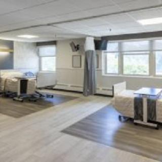 A modern hospital room with multiple beds and a bright interior.
