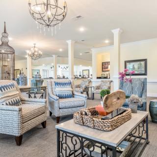 A beautifully designed living room with elegant chandeliers, stylish furniture, and bright lighting.