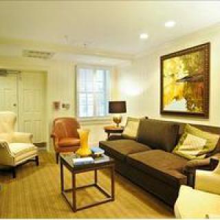 A cozy living room featuring a comfortable sofa, armchairs, and modern artwork.