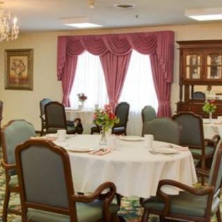 A cozy dining room with elegantly set tables and floral decorations.