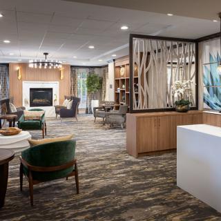 A modern lobby featuring comfortable seating and a fireplace.