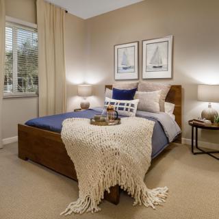 A cozy, well-decorated bedroom with a neatly made bed and soft lighting.