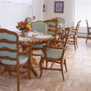 A dining room featuring a wooden table with matching chairs and a decorative centerpiece.