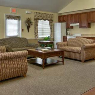 A cozy living room with comfortable seating and a kitchen area in the background.