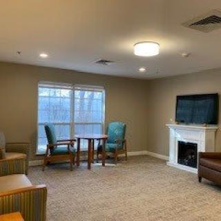 A cozy living room with a television, fireplace, and seating area.