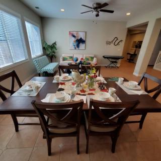 A well-set dining room table prepared for a meal, featuring stylish decor and comfortable seating.