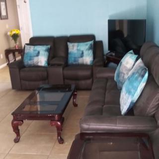 A cozy living room with leather sofas, a coffee table, and decorative throw pillows.