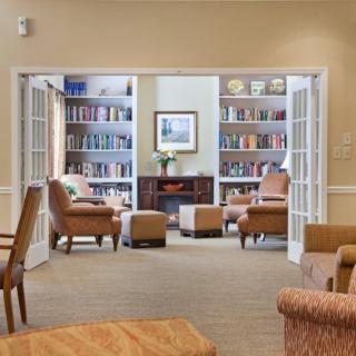 A cozy reading area with bookshelves and armchairs.