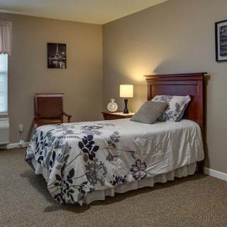 A cozy bedroom with a single bed, bedside lamp, and simple decor.