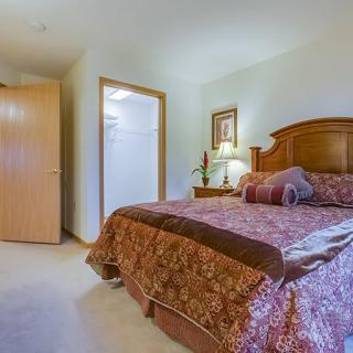 A cozy bedroom with a wooden bed frame and warm decor.