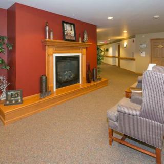A cozy interior setting featuring a fireplace and seating area along a hallway.