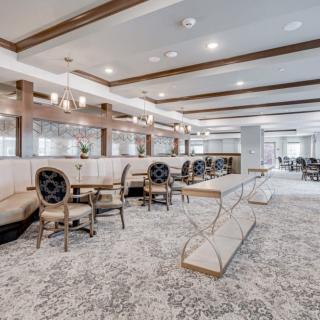 A modern and elegant restaurant interior featuring stylish seating and chandeliers.
