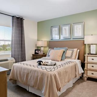 A modern and cozy bedroom with a king-sized bed, two nightstands, and decorative lamps.