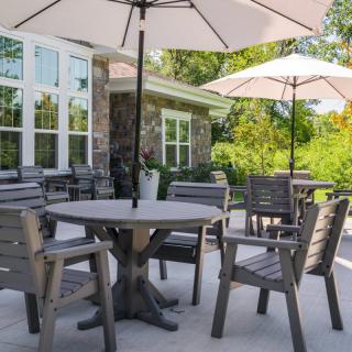 A cozy patio area with wooden tables and chairs under large umbrellas.