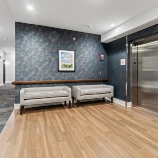 Modern lobby with seating area and elevator.