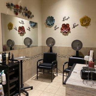 A cozy salon corner with chairs and hair dryers, featuring decorative wall flowers.
