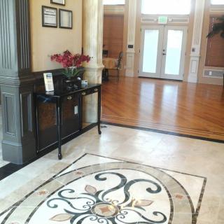 Elegant entryway with a decorative marble floor and a console table adorned with flowers.