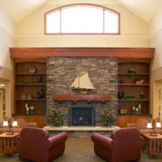 Cozy living room with a stone fireplace and comfortable armchairs.