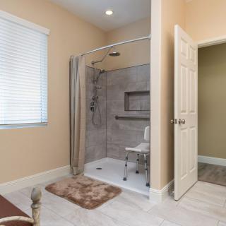 An accessible bathroom with a spacious walk-in shower, equipped with a curtain and a seating area.