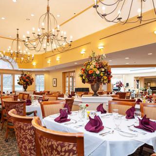 An elegant dining room with chandeliers and decorative table settings.