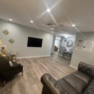 A modern living room with grey walls, wood flooring, and minimalist decor.