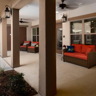 A cozy patio with comfortable outdoor seating and ceiling fans.