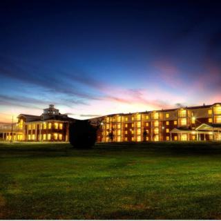 A well-lit building against a colorful evening sky.